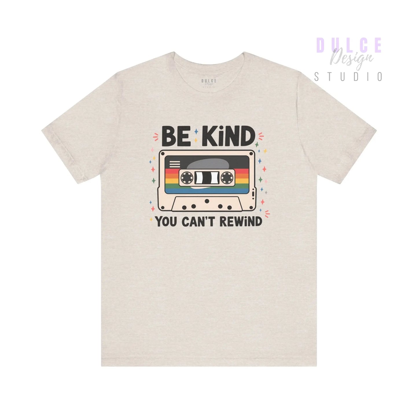Beige t-shirt with a cassette tape graphic and 'Be Kind You Can't Rewind' text on a white background