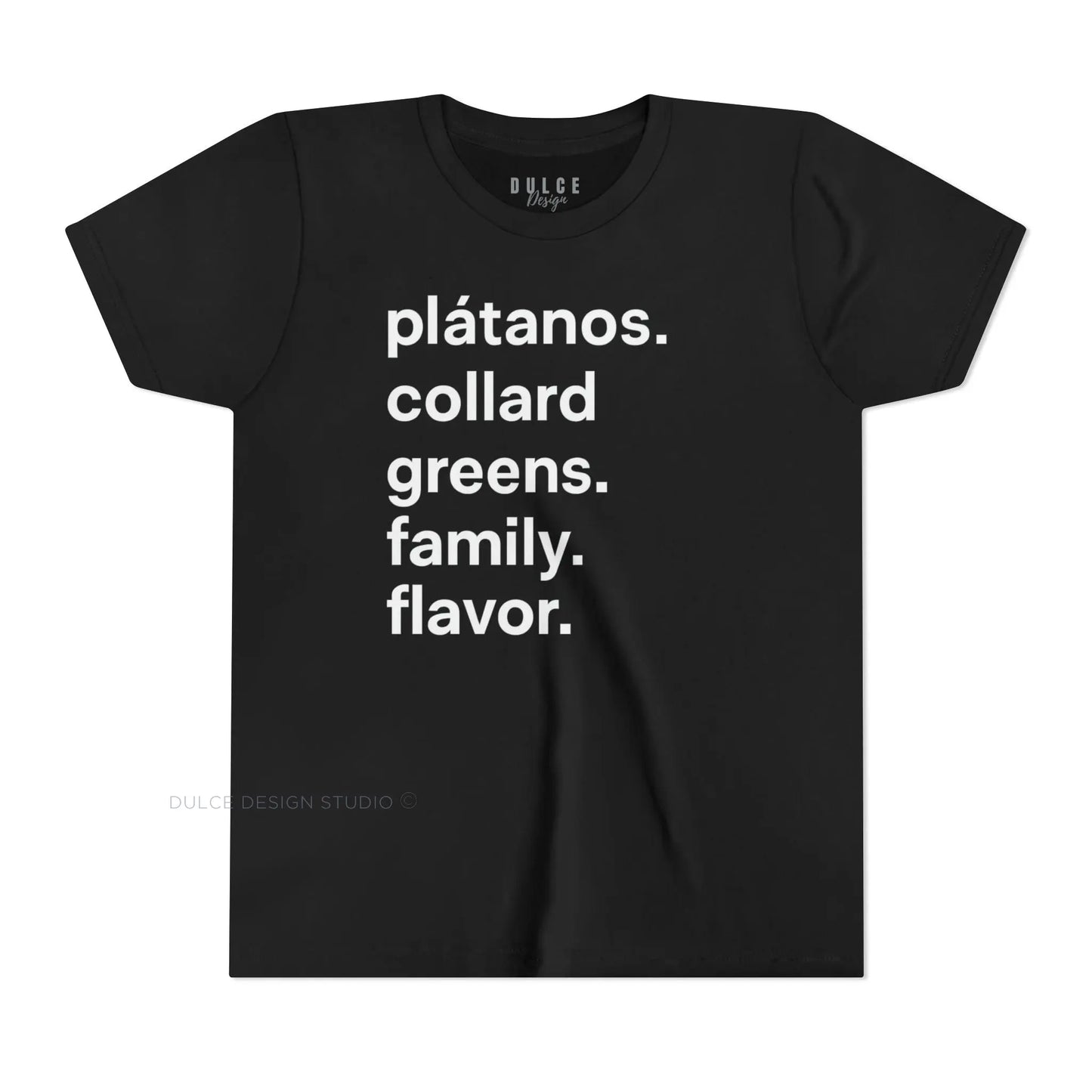 A child wearing a black crew neck t-shirt with the text 'plátanos. collard greens. family. flavor.' printed in white.