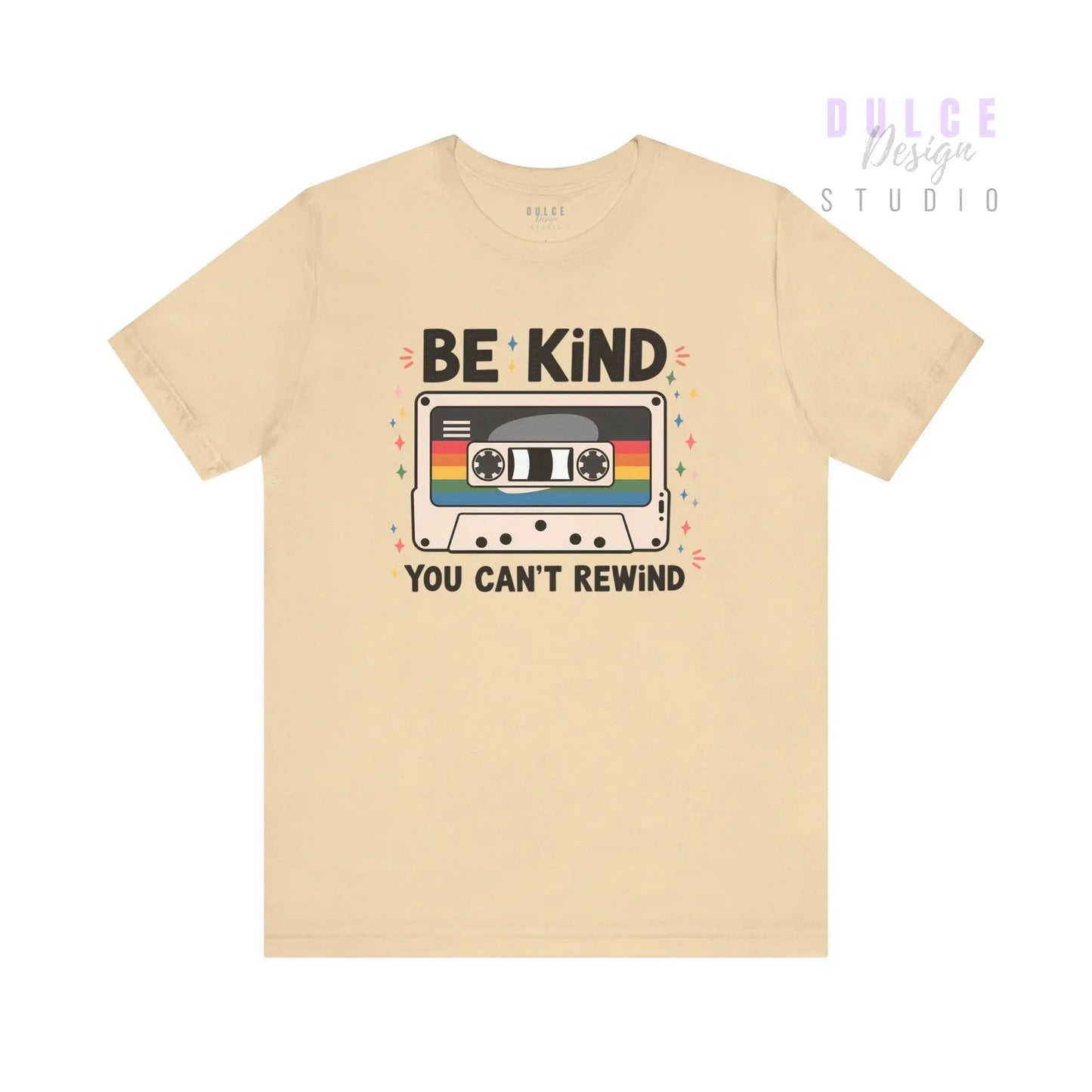 Beige t-shirt with a cassette tape graphic and 'Be Kind You Can't Rewind' text on a white background