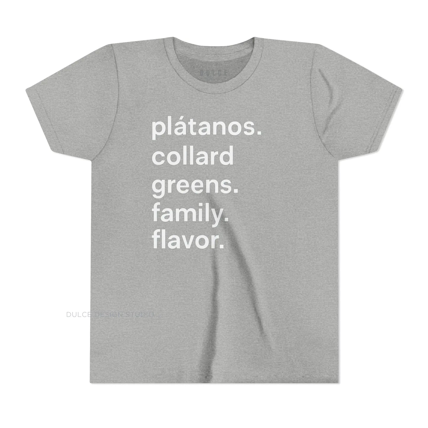 A child wearing a black crew neck t-shirt with the text 'plátanos. collard greens. family. flavor.' printed in white.