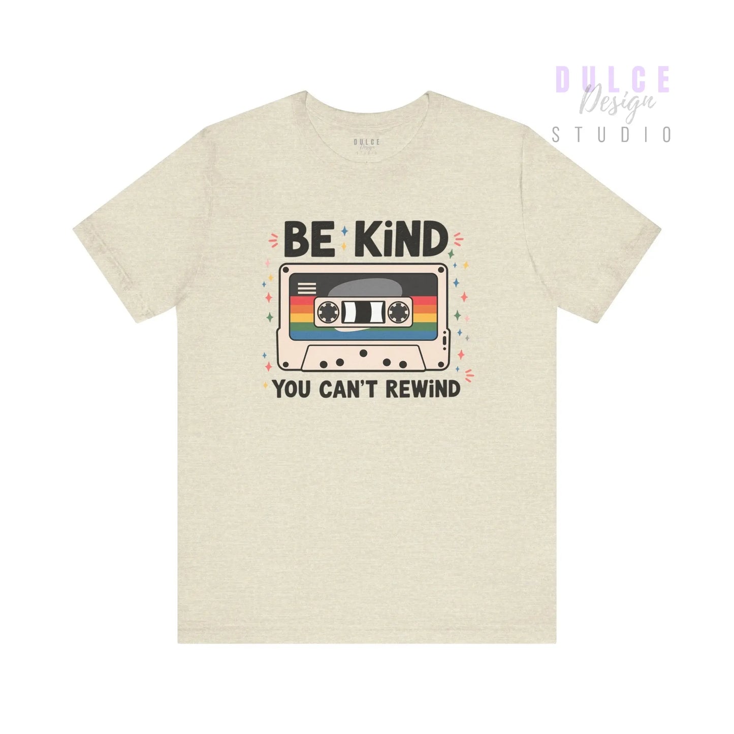 Beige t-shirt with a cassette tape graphic and 'Be Kind You Can't Rewind' text on a white background
