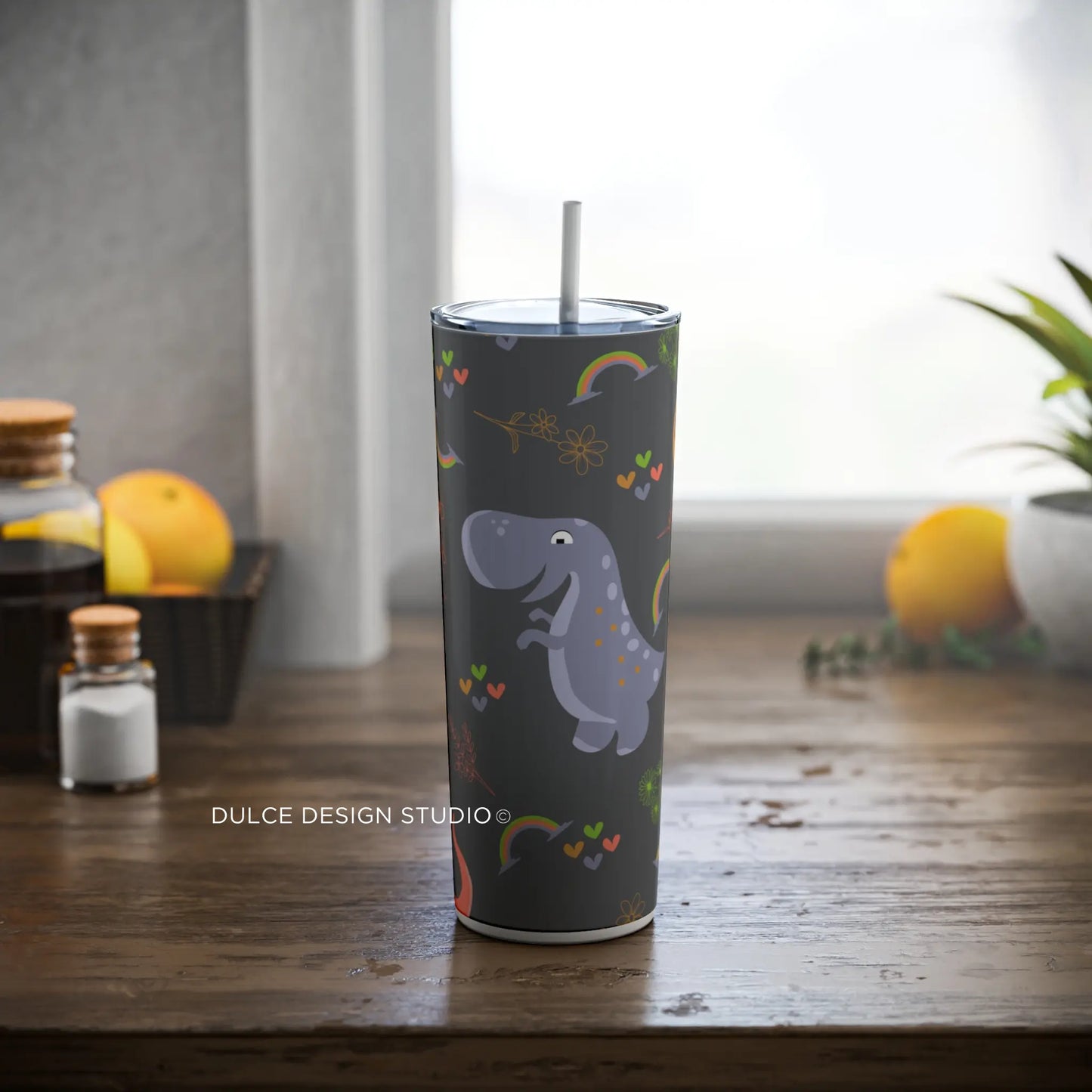 Kids’ dinosaur-themed 20oz tumbler with cute rainbow, hearts, and floral doodles on a dark background by Dulce Design Studio