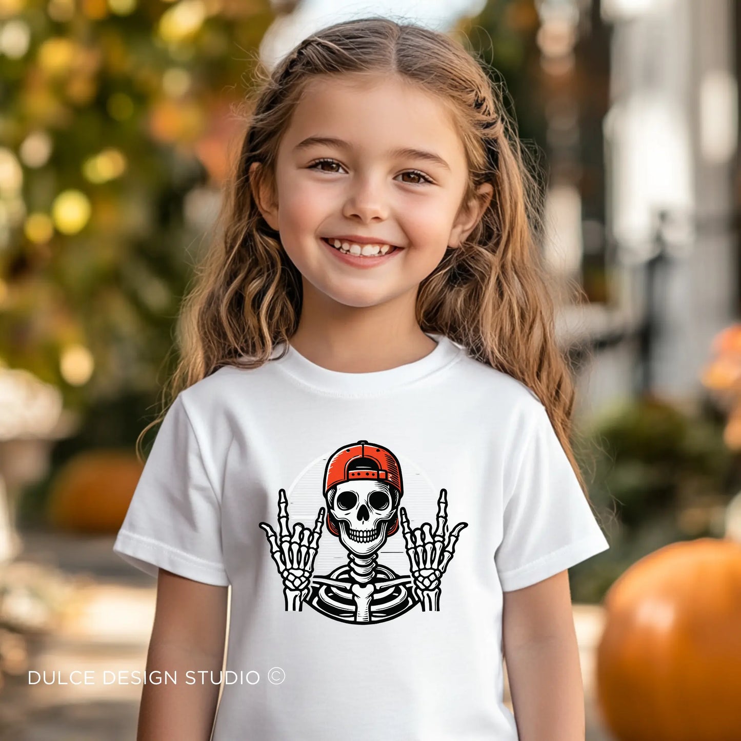 Young Girl wearing a Rocker Skeleton Unisex Halloween Tee with a cool skeleton wearing a red cap, perfect for a rockstar Halloween look.