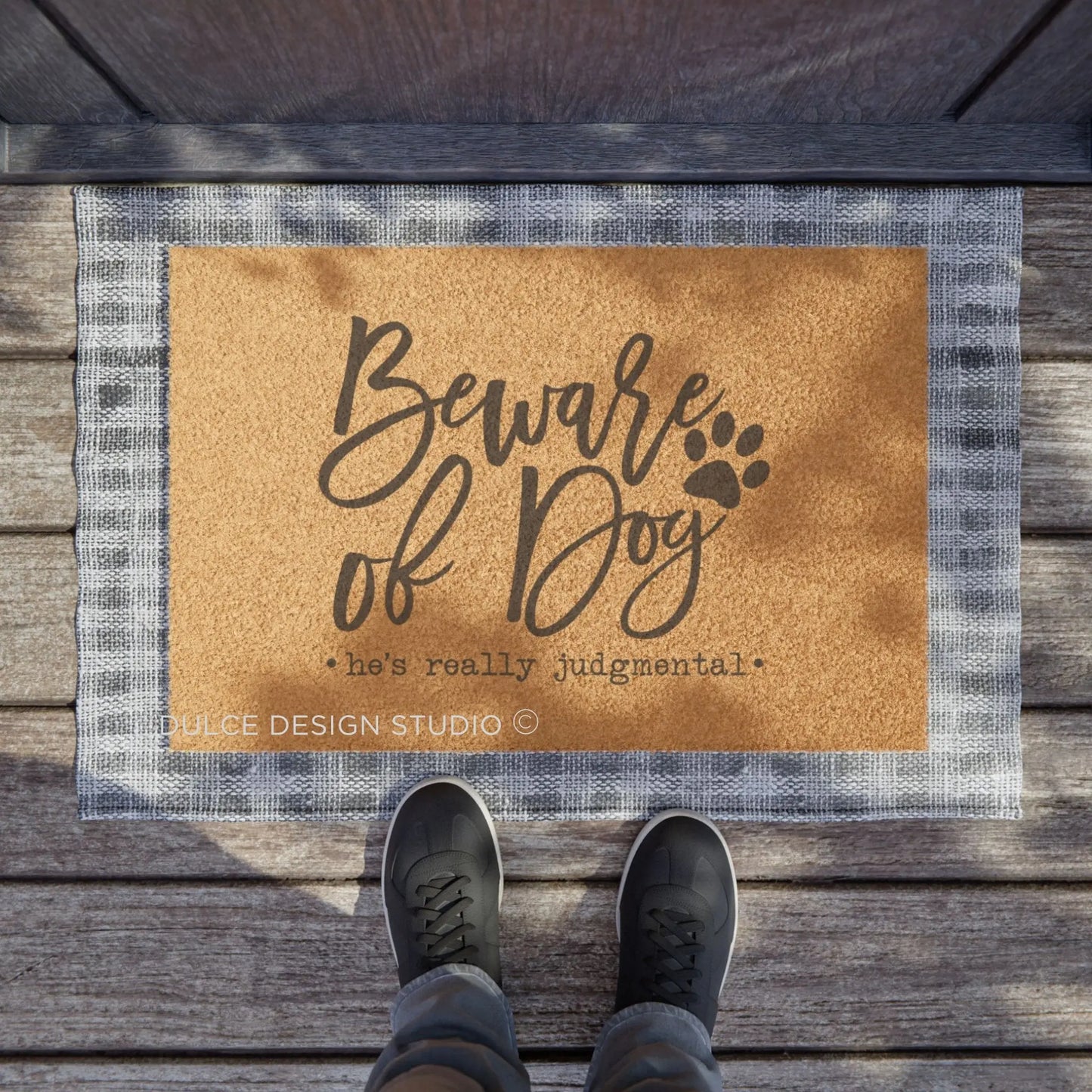 Coir doormat with the phrase “Beware of Dog – He’s Really Judgmental” in playful script with paw print