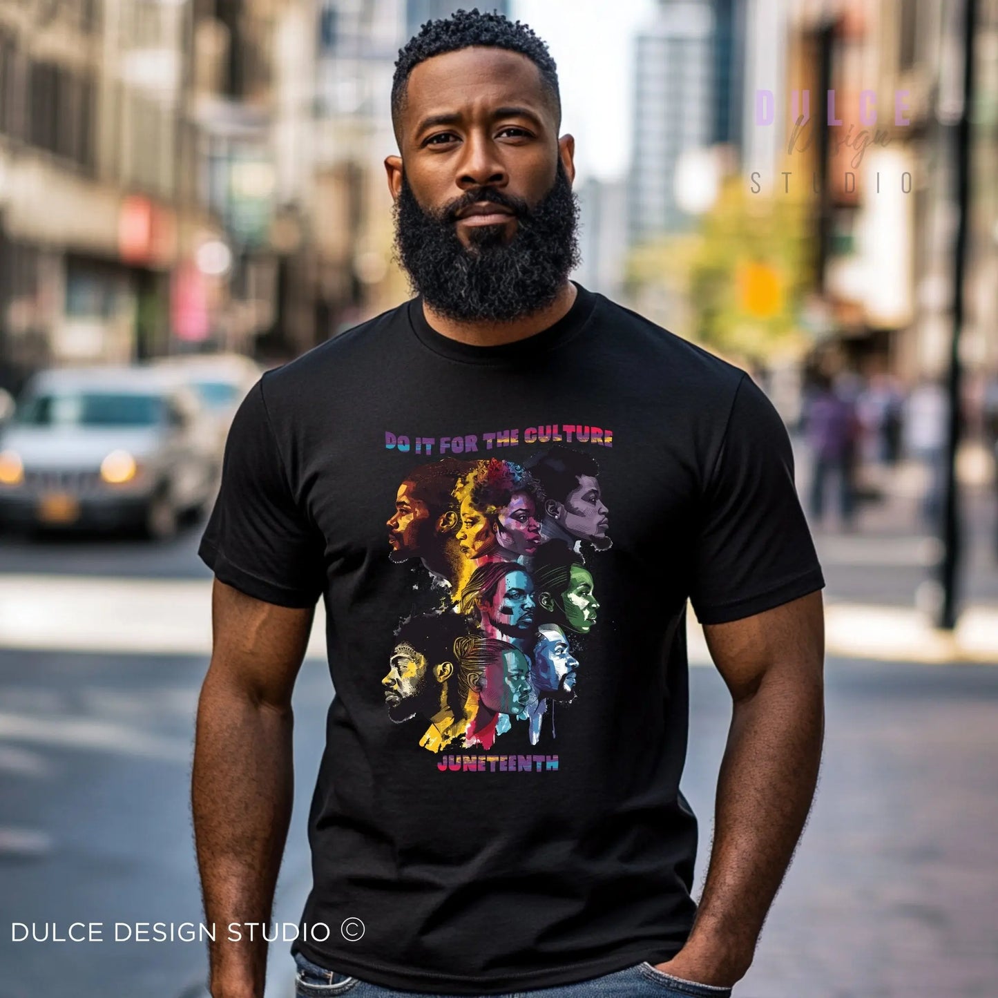 Man wearing a black t-shirt with colorful Do it for the culuture, Juneteenth graphic design on a city street