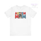 White t-shirt with colorful “Autism Mom” text and mom bun graphic featuring puzzle patterns