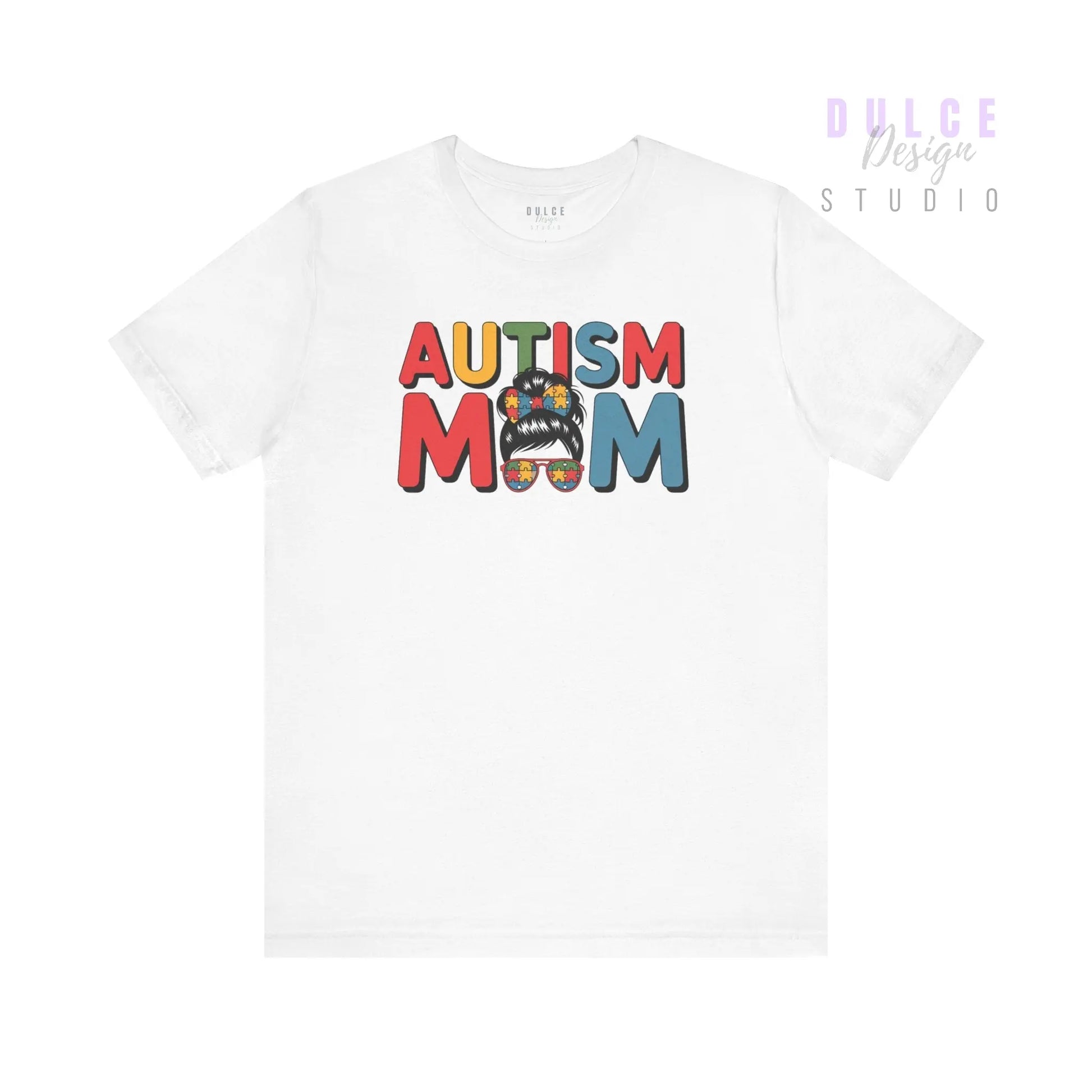 White t-shirt with colorful “Autism Mom” text and mom bun graphic featuring puzzle patterns