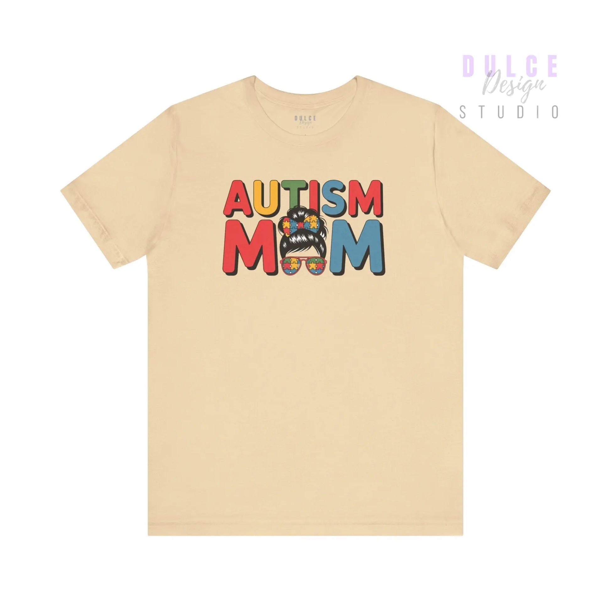 Beige t-shirt with 'AUTISM MOM' text and colorful design on a white background