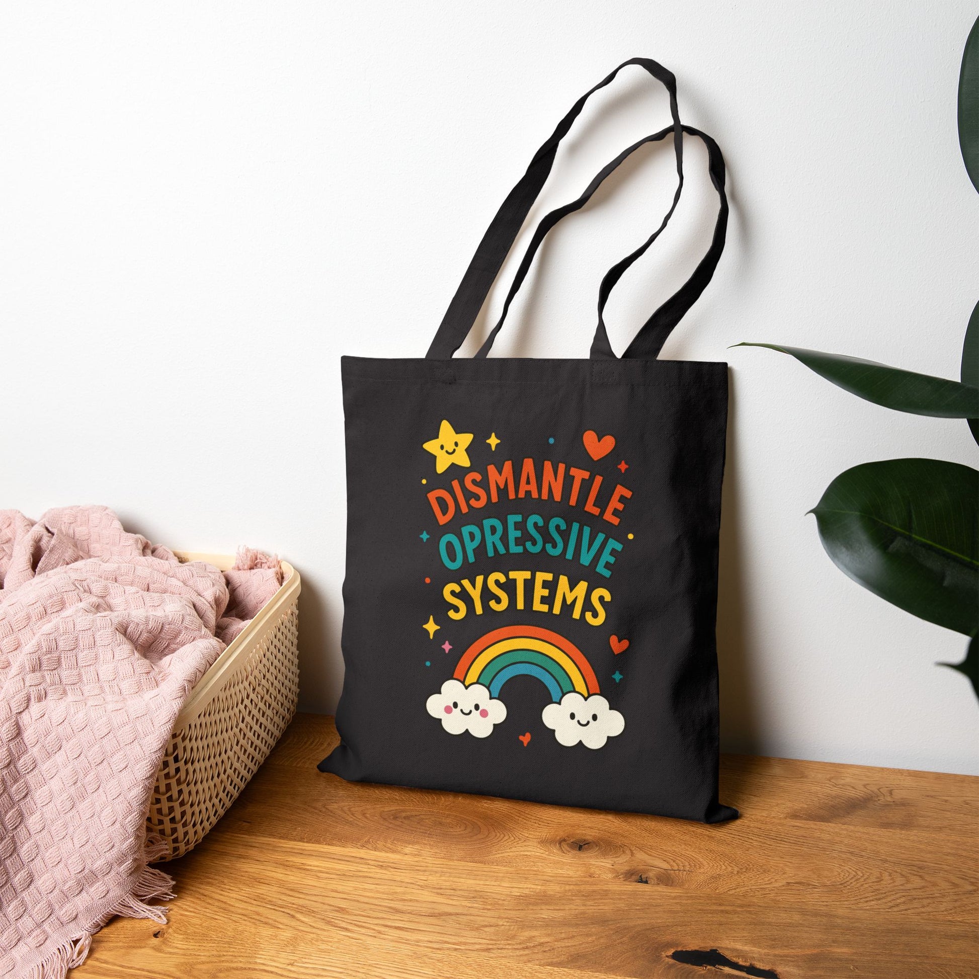 black Canvas tote bag with colorful rainbow design and text reading ‘Dismantle Oppressive Systems’ with clouds and stars