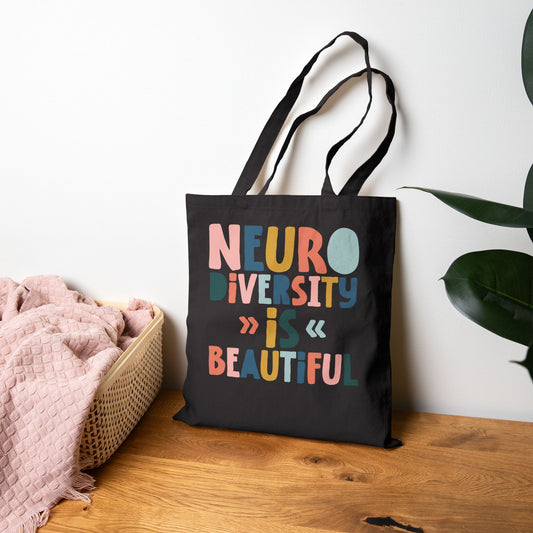 black Canvas tote bag with colorful text reading ‘Neurodiversity Is Beautiful’ in playful font styles