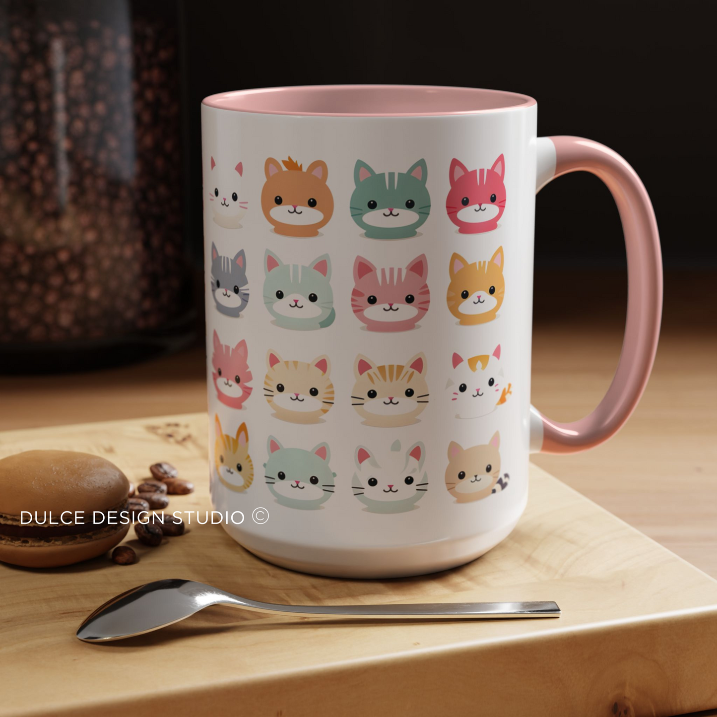 White ceramic kawaii cat mug with colorful cartoon kitty faces and pink handle