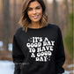 White crewneck sweatshirt with retro-style “It’s a Good Day to Have a Good Day” quote