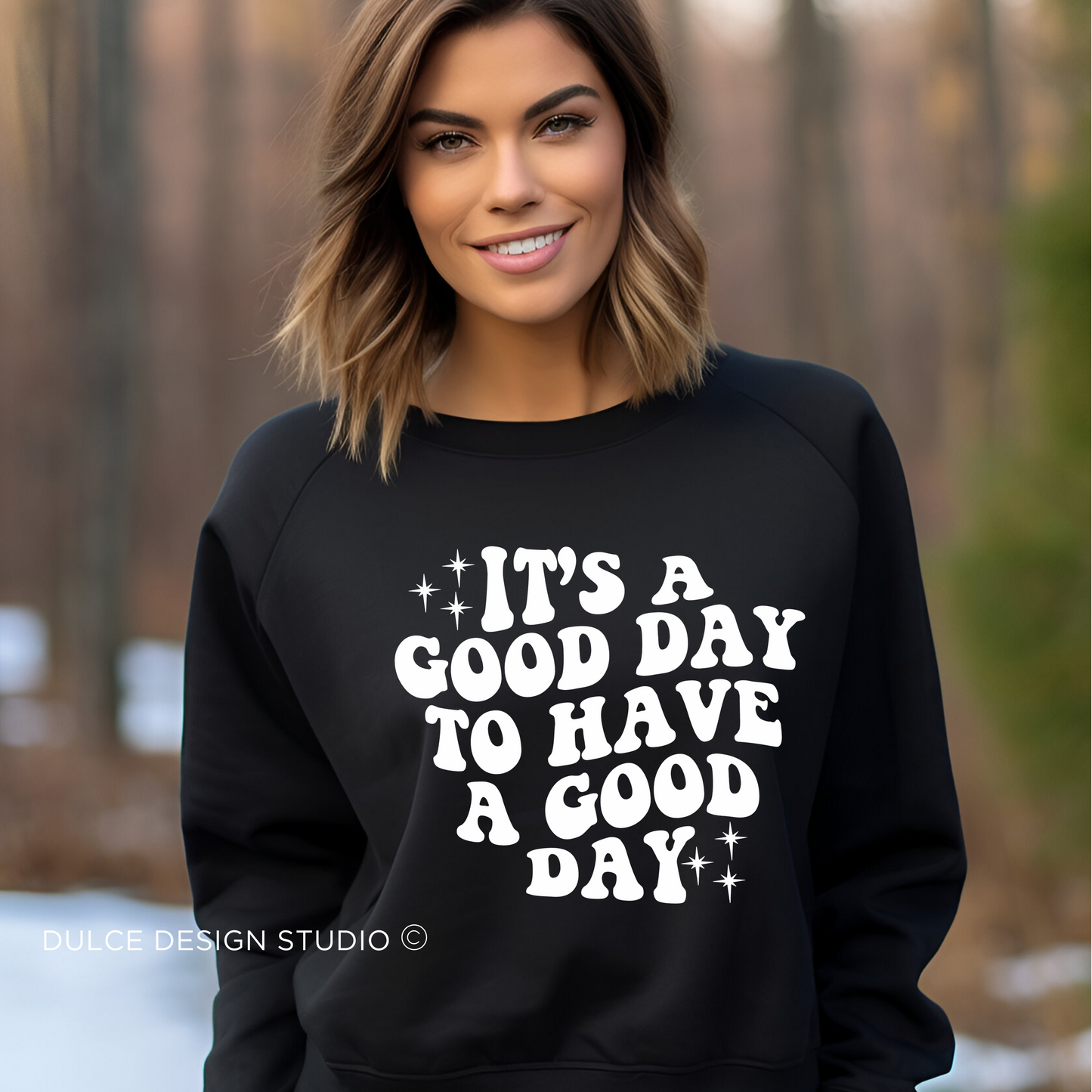 Person wearing a black sweatshirt with the text "It's a Good Day to Have a Good Day" in white letters