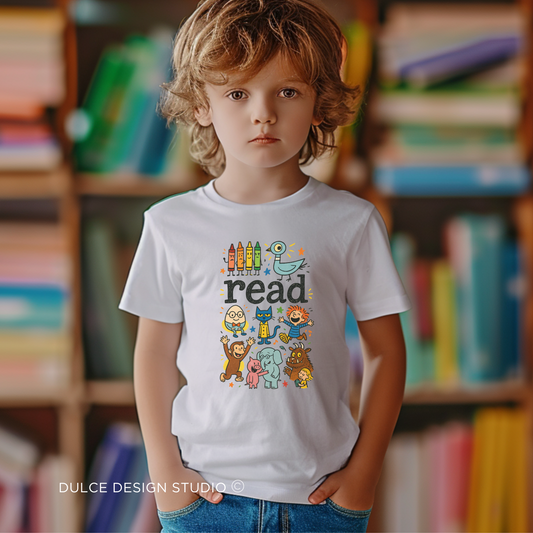 young boy wearing White kids t-shirt with colorful ‘read’ text surrounded by storybook characters like crayons, pigeon, monkey, and elephant