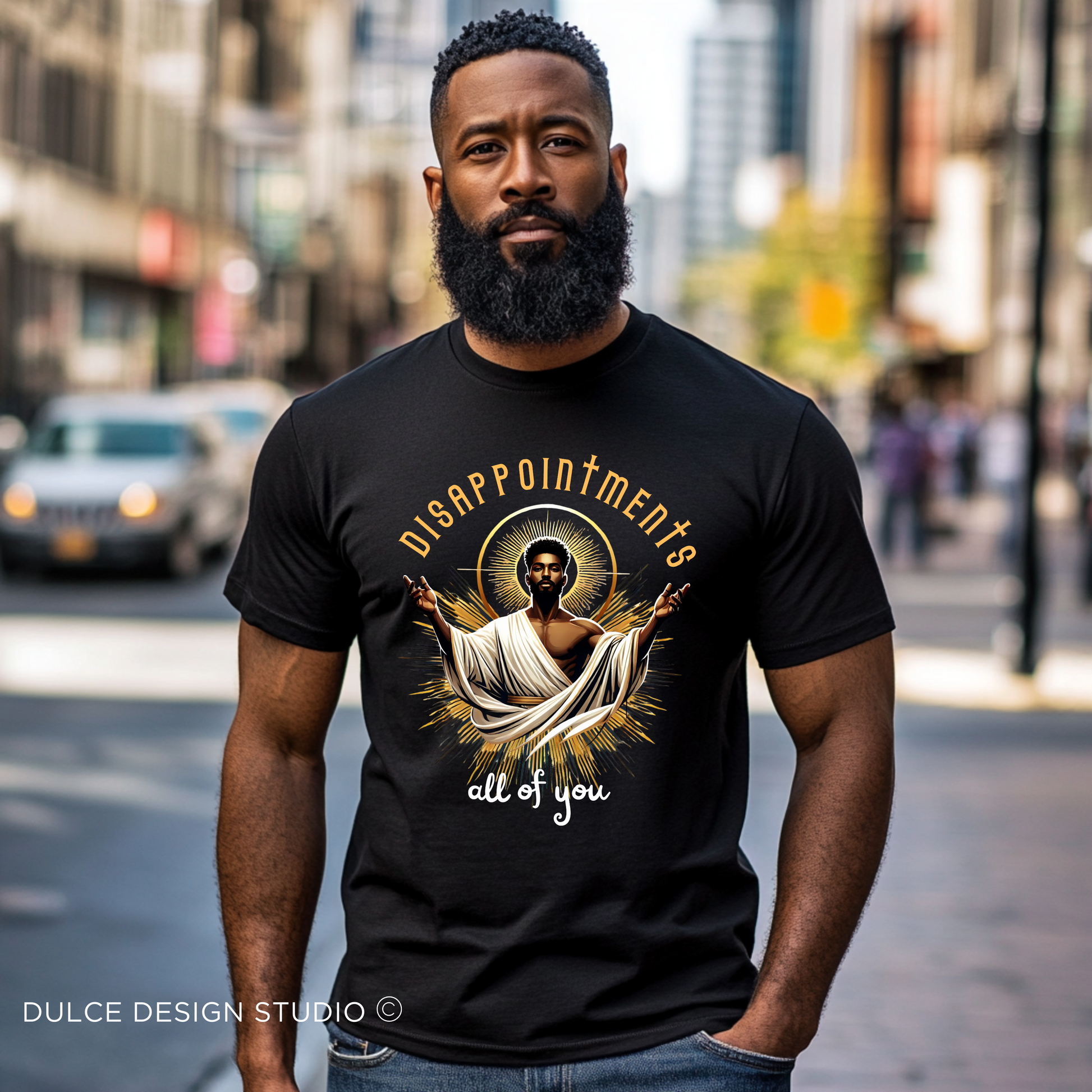 Man wearing a black ‘Disappointments All of You’ T-shirt with a saint-like figure and a glowing aura