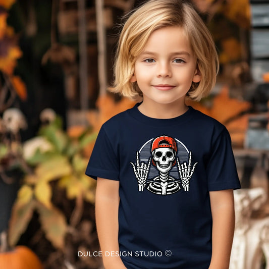 Young child wearing a Rocker Skeleton Unisex Halloween Tee with a cool skeleton wearing a red cap, perfect for a rockstar Halloween look.