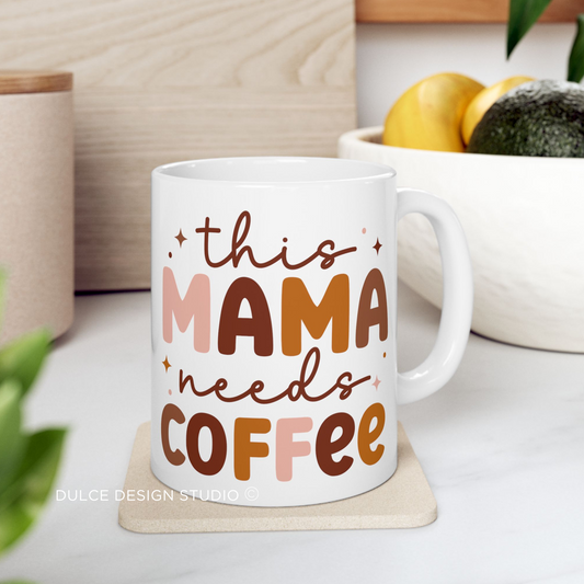 White ceramic coffee mug with “This Mama Needs Coffee” printed in script