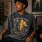 Man wearing a t-shirt with a graphic design and text, sitting in a room with decor elements.