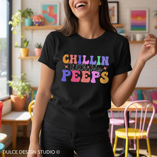 Person wearing a black t-shirt with colorful text in a casual setting