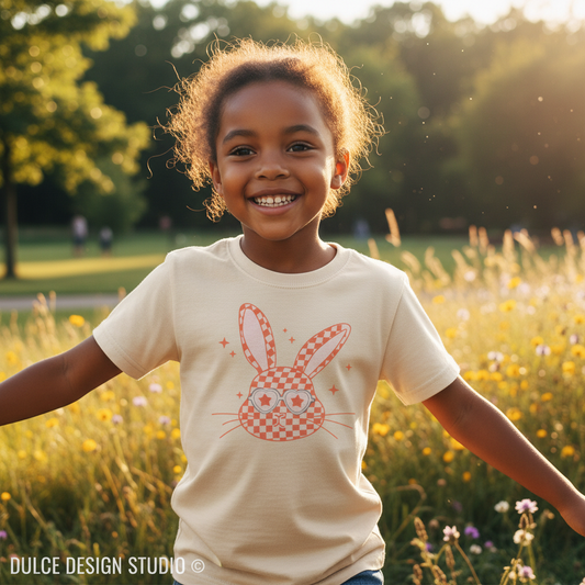 Child wearing a t-shirt with a bunny design in a field of flowers