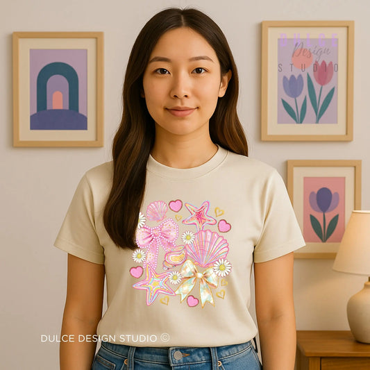Woman wearing a beige t-shirt with colorful starfish design in a room with framed artwork on the wall.