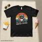 Black t-shirt with a raccoon graphic and text 'Dad Tax' on a beige surface with sunglasses, fries, and ice cream.