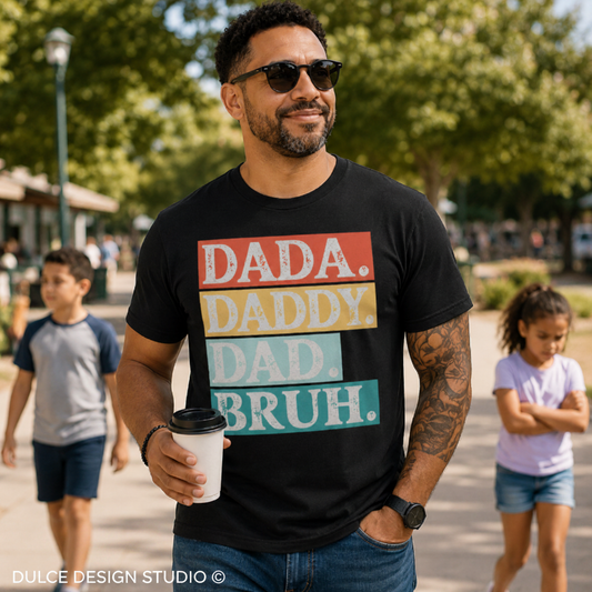 Man wearing a black t-shirt with colorful text in an outdoor setting