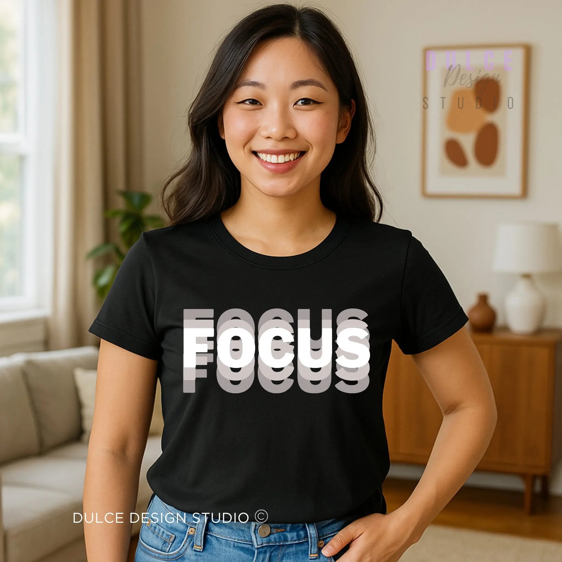 Woman wearing a black t-shirt with 'FOCUS' text in a living room setting