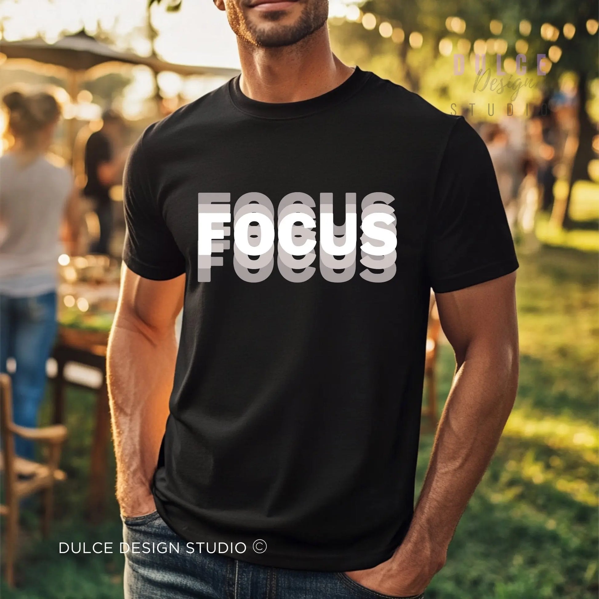 Man wearing a black t-shirt with 'FOCUS' printed on it, standing outdoors.