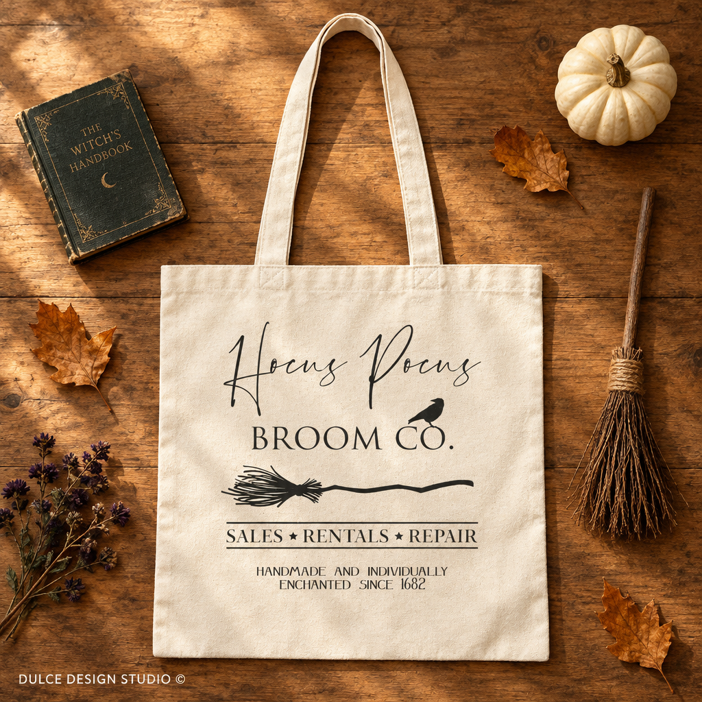 Natural canvas Hocus Pocus Broom Co tote flat lay with a book, broom, pumpkin, and autumn leaves