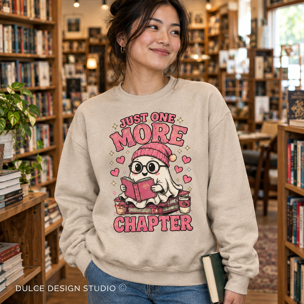 Woman in a bookstore wearing a sand Just One More Chapter ghost book lover crewneck sweatshirt.