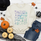 Cream crewneck sweatshirt flat lay with colorful pastel Spooky Season witch, pumpkin, skull, and ghost design