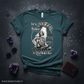 Green t-shirt with a graphic design featuring text and a character, placed on a dark surface with decorative elements.