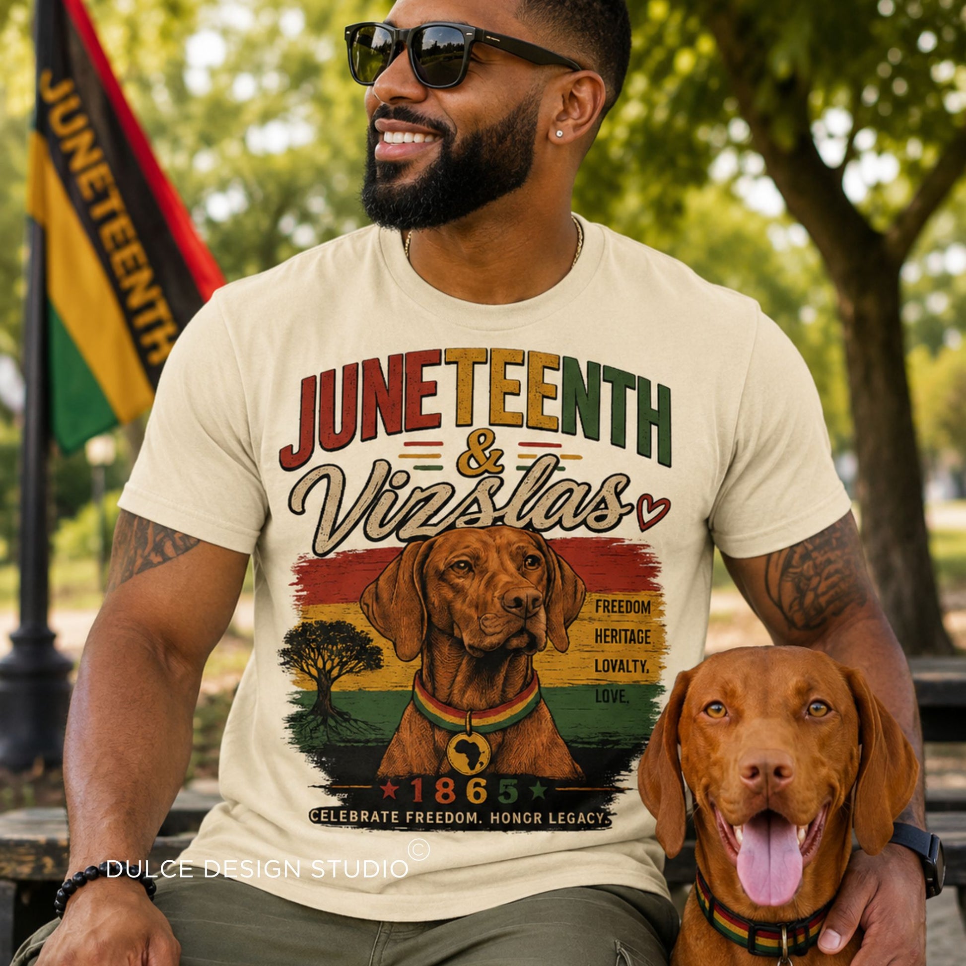 Man wearing a 'Juneteenth & Vizslas' t-shirt with a dog, sitting outdoors.