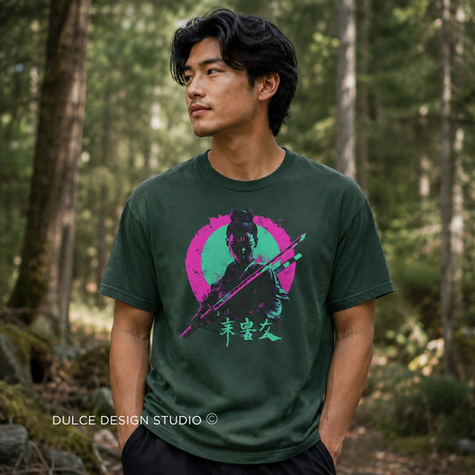 A man wearing a dark green graphic t-shirt with a stylized samurai print in pink, green, and black, standing in a forest. The watermark 'DULCE DESIGN STUDIO' is visible in the bottom left corner.