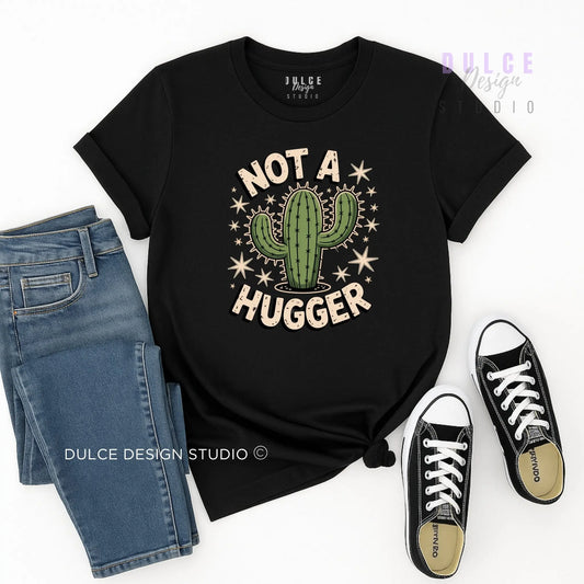 Black t-shirt with cactus graphic and 'Not a Hugger' text, paired with jeans and sneakers on a white background.