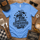 Blue t-shirt with skeleton design and text on a wooden surface with Father's Day decor.