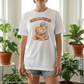 Person wearing a white t-shirt with cartoon monkeys and text 'SMOL BUT FIERCE' in a room with plants.