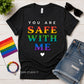 Heather Black t-shirt with 'You are safe with me' text in rainbow colors, surrounded by accessories on a wooden surface.