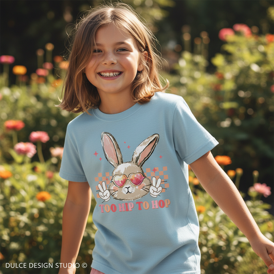 Child wearing a light blue t-shirt with a bunny design in a garden setting