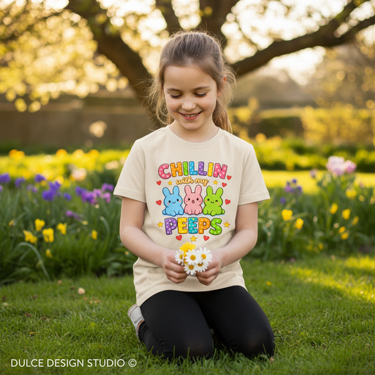 Young girl wearing a 'Chillin with my Peeps' shirt in a garden setting.